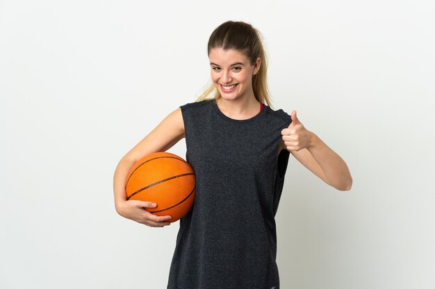 Joven mujer rubia jugando baloncesto y con el pulgar hacia arriba