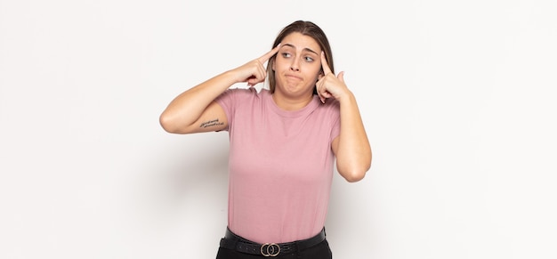 Joven mujer rubia mirando concentrada y pensando mucho en una idea, imaginando una solución a un desafío o problema