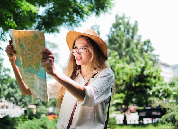 Joven mujer rubia mirando el mapa de la ciudad