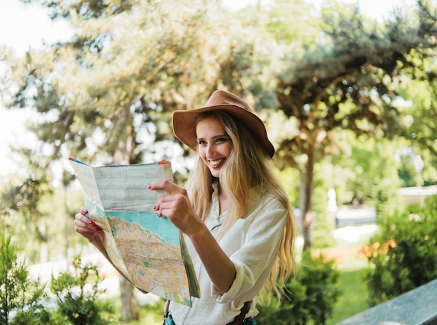 Foto joven mujer rubia mirando el mapa de la ciudad