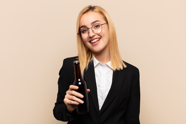 Joven mujer rubia que parece feliz y gratamente sorprendida, emocionada con una expresión fascinada y conmocionada