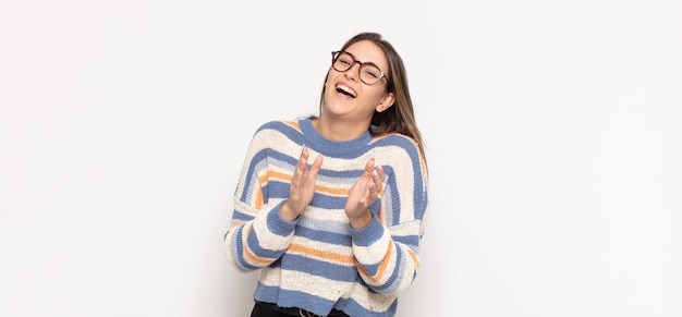 Joven mujer rubia que se siente feliz y exitosa, sonriendo y aplaudiendo, felicitando con un aplauso