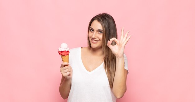 Joven mujer rubia que se siente feliz, relajada y satisfecha, mostrando aprobación con gesto bien, sonriendo