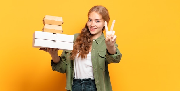 Joven mujer rubia quitando comida rápida