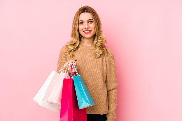 Joven mujer rubia sosteniendo bolsas de la compra.