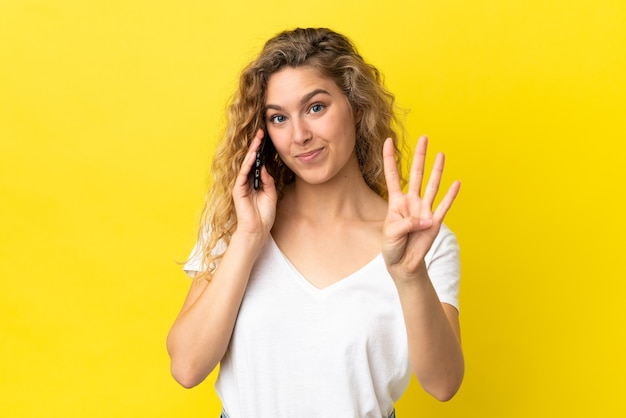 Joven mujer rubia mediante teléfono móvil