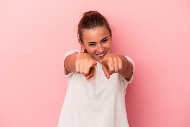 Foto joven mujer rusa aislada sobre fondo rosa apuntando al frente con los dedos.