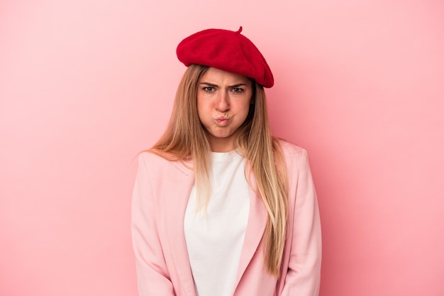 Joven mujer rusa aislada sobre fondo rosa infeliz mirando a puerta cerrada con expresión sarcástica.