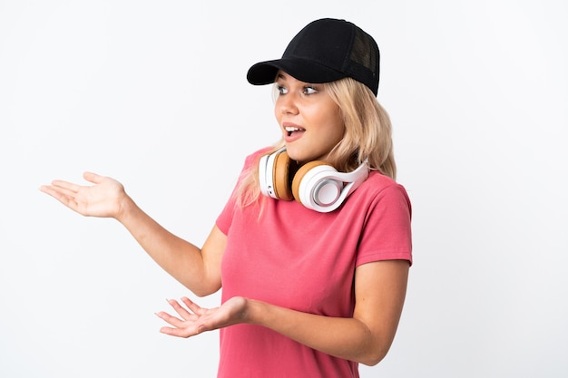 Foto joven mujer rusa escuchando música aislada sobre fondo blanco con expresión de sorpresa mientras mira de lado