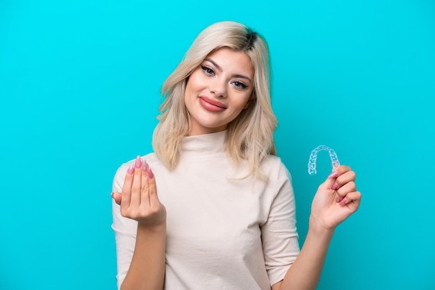 Foto joven mujer rusa sosteniendo invising aislado sobre fondo azul invitando a venir con la mano feliz de que hayas venido