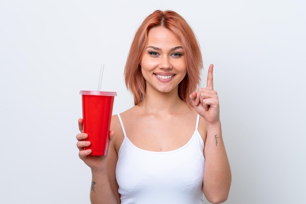 Joven mujer rusa sosteniendo un refresco aislado de fondo blanco apuntando a una gran idea