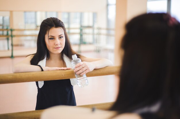 Joven mujer sana agua potable en fitness