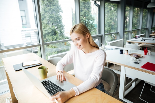 Joven mujer sentada en la oficina de coworking