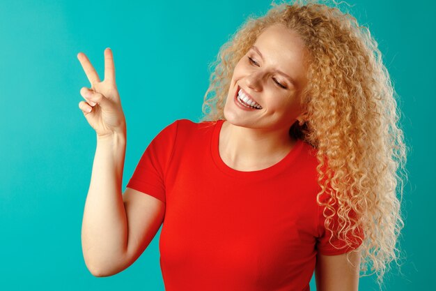 Joven mujer sonriente feliz mostrando el signo de la victoria