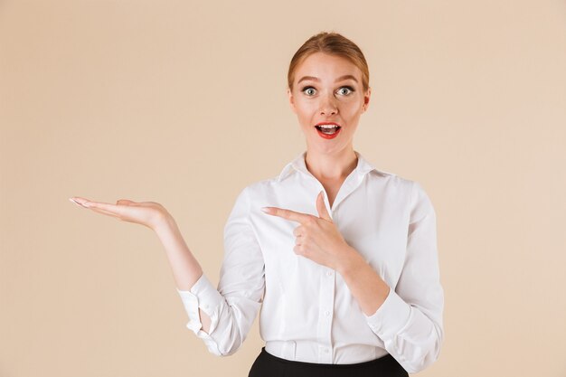 Joven mujer sorprendida apuntando.