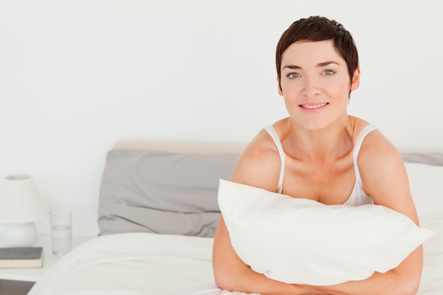 Joven mujer sosteniendo una almohada