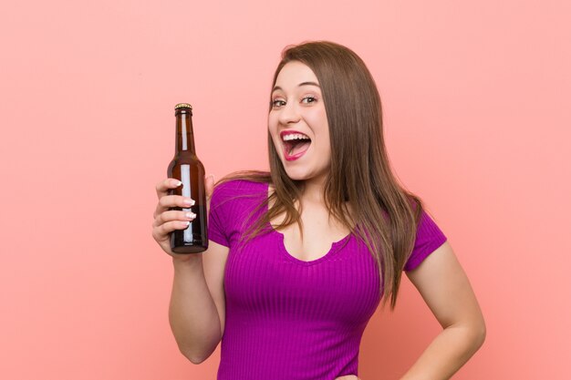 Joven mujer sosteniendo una botella de cerveza