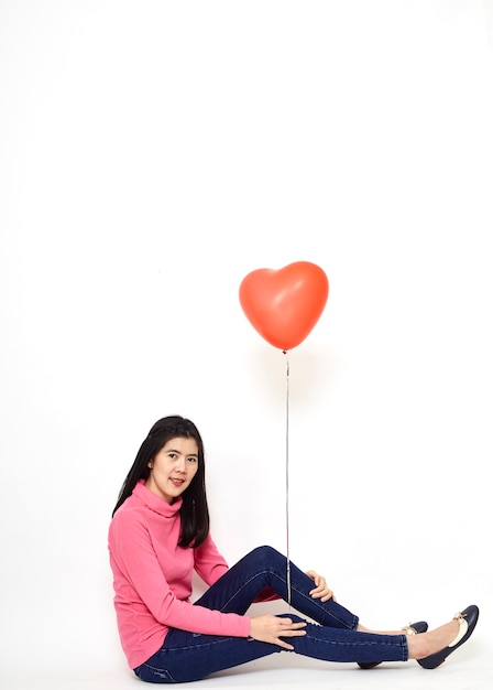 Joven mujer sosteniendo un globo rojo