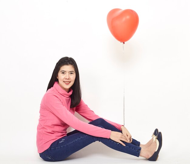 Joven mujer sosteniendo un globo rojo