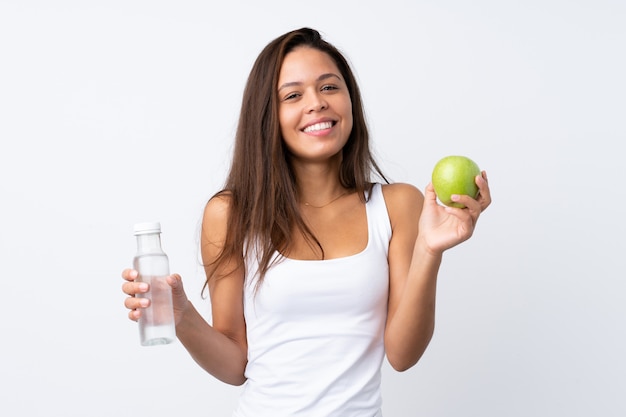 Joven mujer sosteniendo una manzana sobre pared aislada