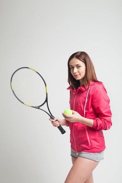 Joven mujer sosteniendo una raqueta de tenis