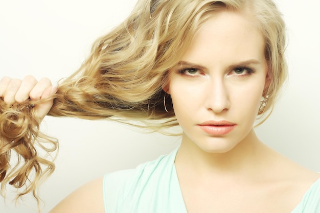 Joven mujer sosteniendo su cabello largo y rizado sano