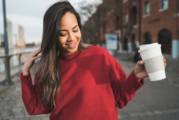 Joven mujer sosteniendo una taza de café.