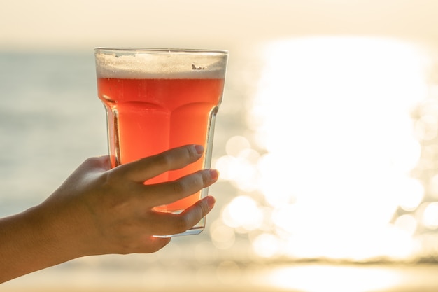 Joven mujer sosteniendo un vaso de cerveza