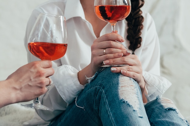 joven mujer sostiene una copa de vino rosado, cita romántica