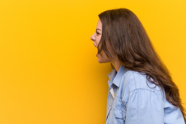 Foto joven mujer de talla grande con curvas gritando hacia un espacio en blanco