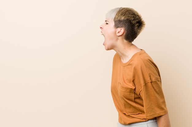 Foto joven mujer de talla grande con pelo corto gritando hacia un espacio de copia