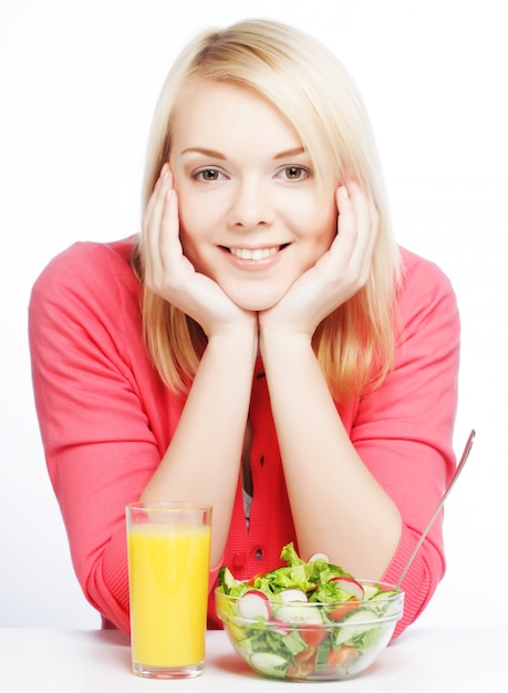 Joven mujer tiene ensalada de desayuno