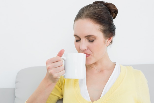 Joven mujer tomando café en casa