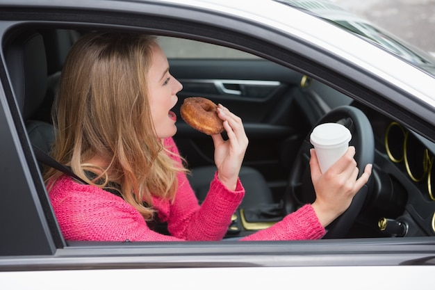 Joven mujer tomando café y donut