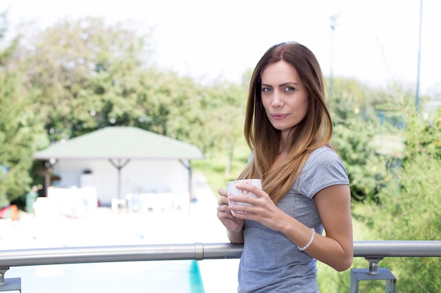 Joven mujer tomando un café en la terraza