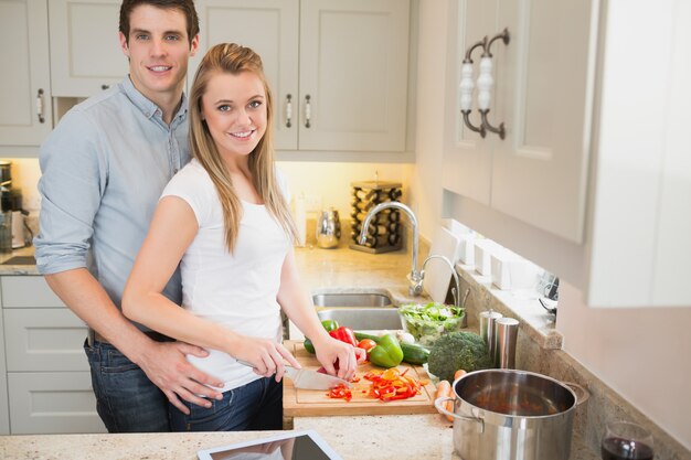 Joven y mujer trabajando felizmente juntos en la cocina