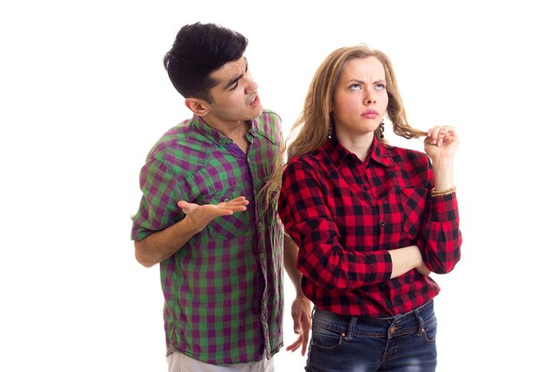 Foto joven mujer triste con cabello largo castaño y joven arrogante en camisas a cuadros discutiendo en el estudio