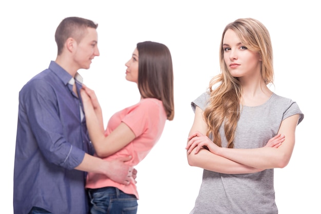 Joven mujer triste de pie con los brazos cruzados.