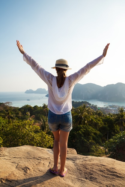 Foto joven mujer viajera disfrutando de una gran vista junto al mar