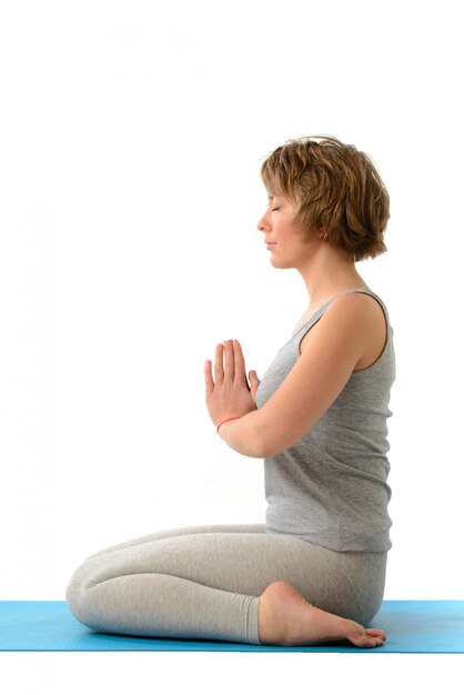 Foto joven mujer de yoga en la posición de virasana. aislado en la pared blanca