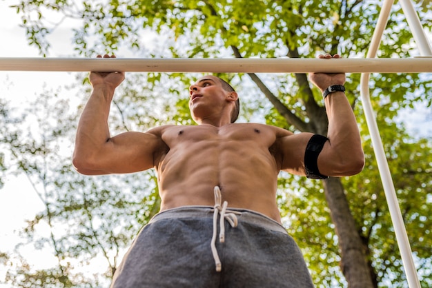 Joven musculoso durante su entrenamiento en la calle.