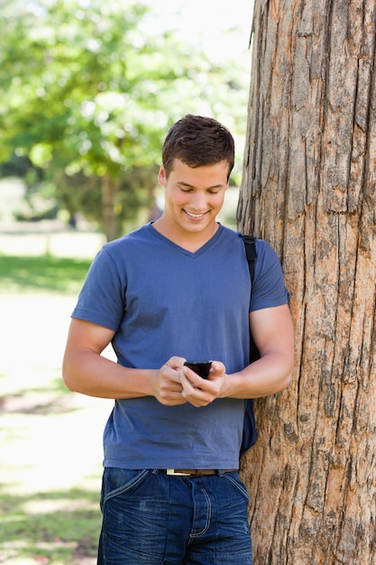 Joven musculoso con un teléfono inteligente