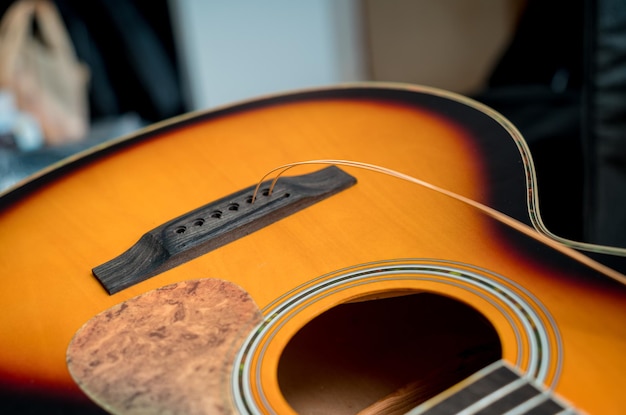 Foto joven músico cambiando cuerdas en una guitarra clásica en una tienda de guitarras