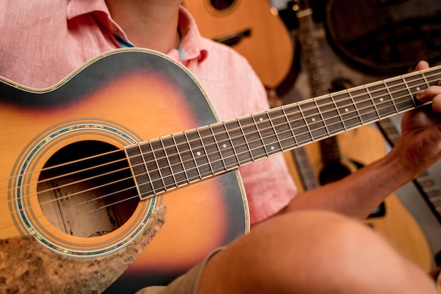 Joven músico probando la guitarra clásica en una tienda de guitarras