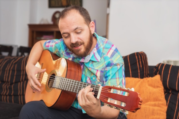 Joven músico tocando la guitarra acústica