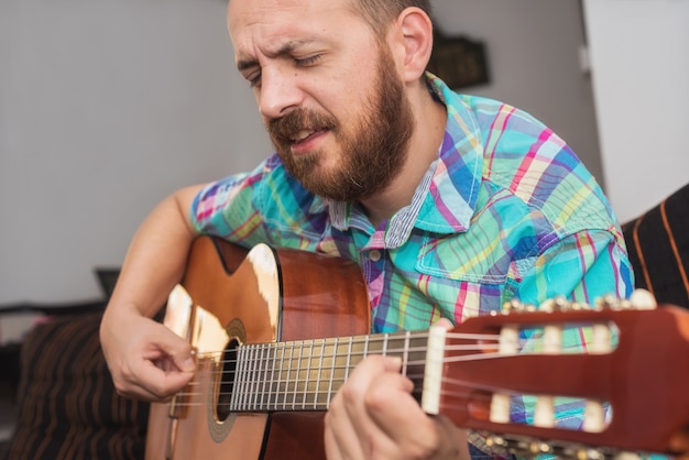 Foto joven músico tocando la guitarra acústica