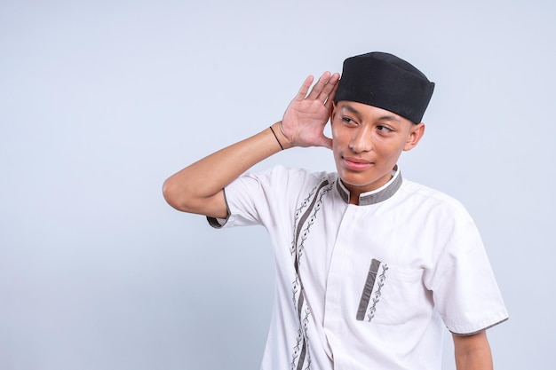Foto joven musulmán asiático puso la mano cerca de la oreja tratar de escuchar sonido o noticias secretas