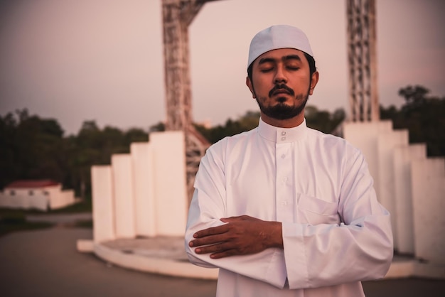 Un joven musulmán asiático rezando al atardecer concepto del festival del Ramadán