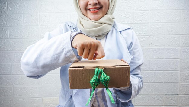 Joven musulmán dando regalos de Eid en una caja