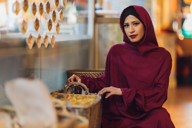 Joven musulmana árabe sentada en un café
